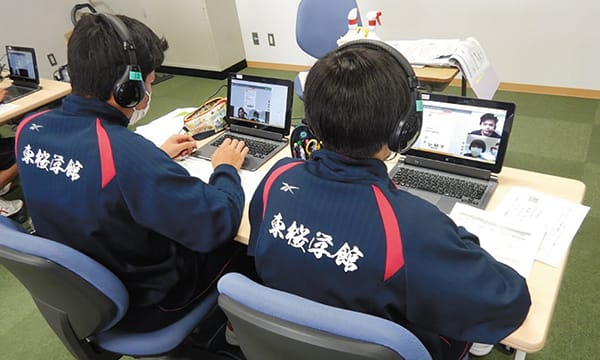生徒がそれぞれノートパソコンでオンライン交流をしている様子